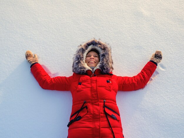 雪の中で幸せな女性。トップフラット俯瞰図。