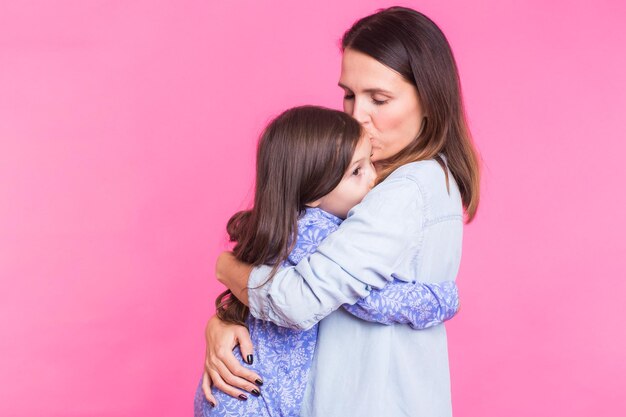 Happy woman standing against pink background