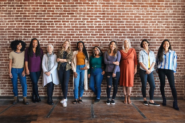 happy woman standing by a brick wall