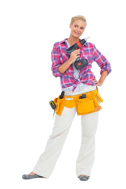 Happy woman standing holding a drill