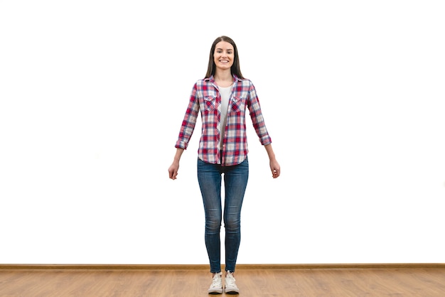 The happy woman standing on the white wall background