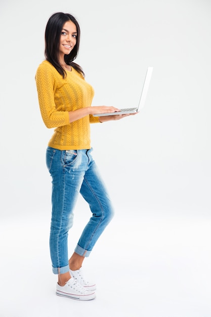 Happy woman standing with laptop