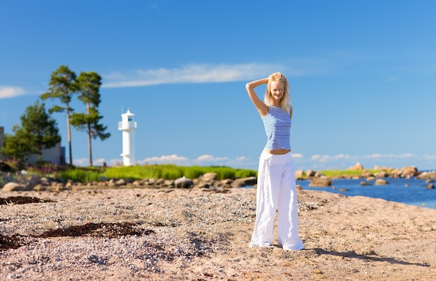 happy woman in striped vest on the seashore