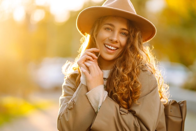 Happy woman in stylish sweater and hat outdoors in autumn park on plaid Woman enjoys autumn nature