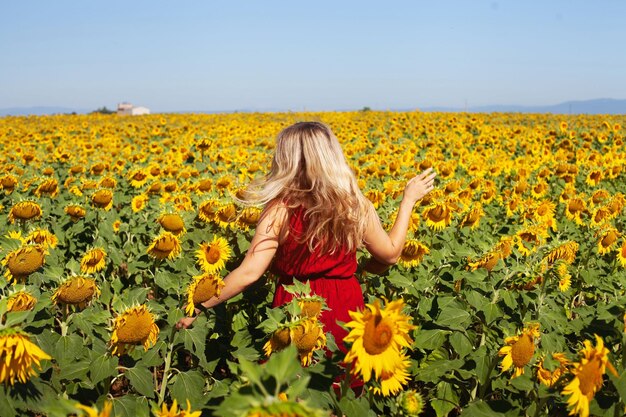 Foto donna felice in un campo di girasoli d'estate che si gode la vita bellezza naturale