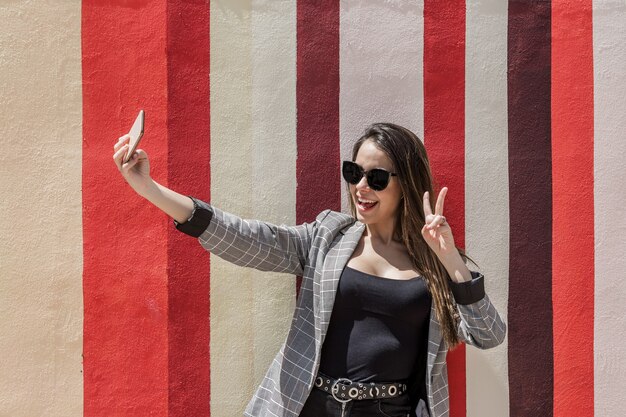 Happy woman taking selfie in city