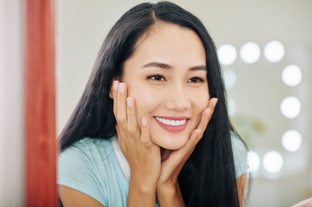 Happy woman touching her face