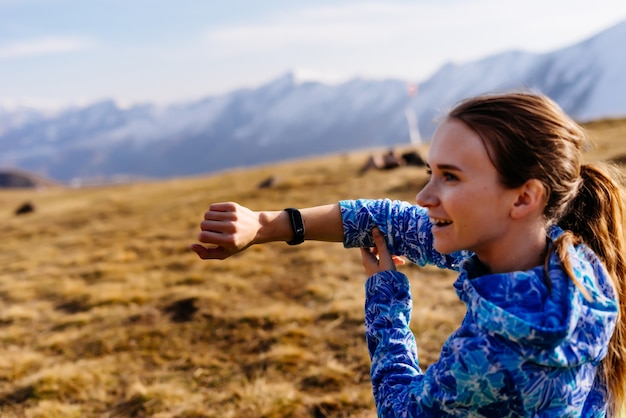 Happy woman tourist sits showing fitness bracelet