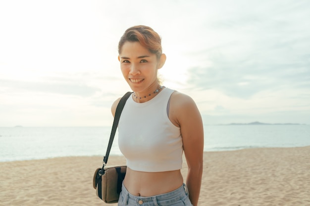 Happy woman tourist walking around the beach in summer