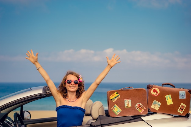 Happy woman travel by car to the sea Girl having fun in cabriolet Summer vacation concept