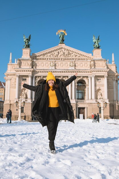 リヴィウ市のオペラの建物の前で幸せな女旅行者