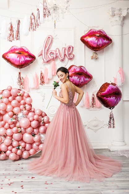 Photo happy woman in tulle dress with pink ballons. luxury