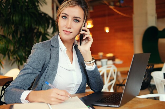 Happy woman using chatting with mobile and use laptop computer and working at cafe restaurantDigital age lifestyleWorking outside office concept