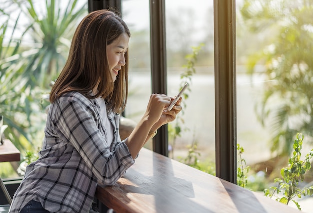 デジタルタブレットを使用してカフェで幸せな女