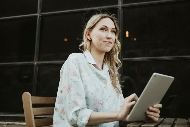 屋外でデジタルタブレットを使用して幸せな女性