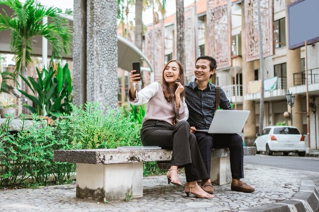 Happy woman using a smart phone taking selfie and video call with her partner