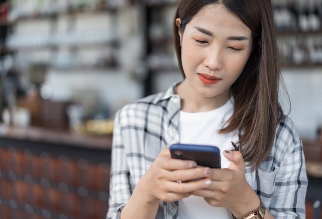 カフェでスマートフォンを使用して幸せな女