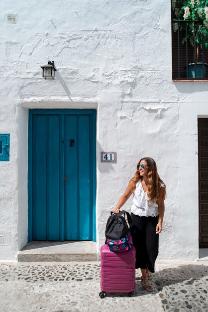 Happy woman on vacation with suitcase