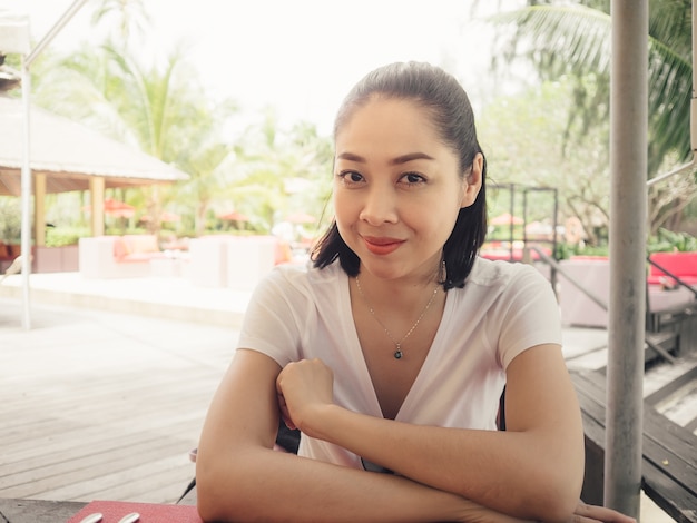 Happy woman waiting for menu in a resort rest.