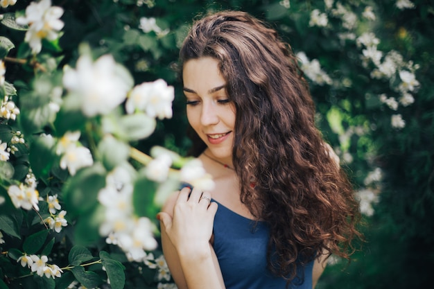 Happy woman walking in an apple orchard in the spring flowers