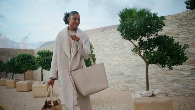 Happy woman walking shopping bags on street smiling african american enjoying