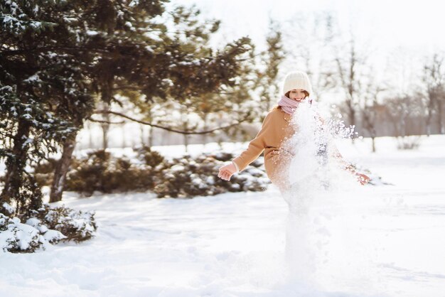 Счастливая женщина, идущая в снежный зимний день на открытом воздухе