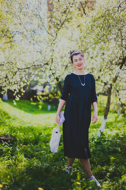 Happy woman walking in the spring cherry garden