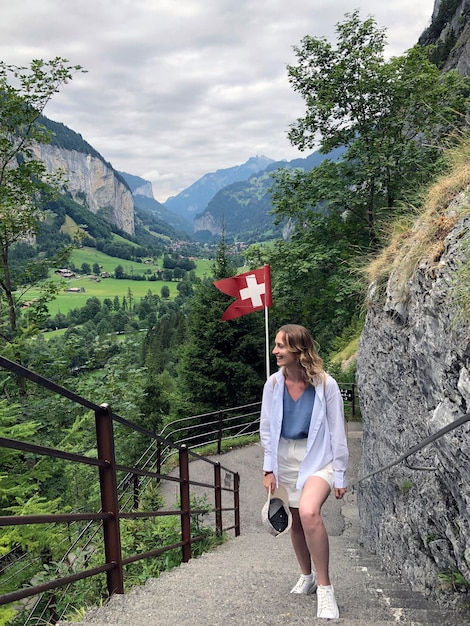 Foto donna felice cammina lungo il ripido sentiero in svizzera escursione nel villaggio di lauterbrunnen, alpi svizzere