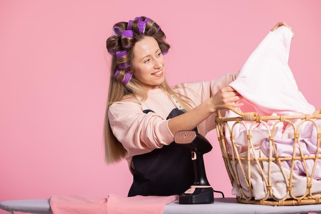 Happy woman washed clothes with new powder removes shirt from\
wicker basket watches stains peel away