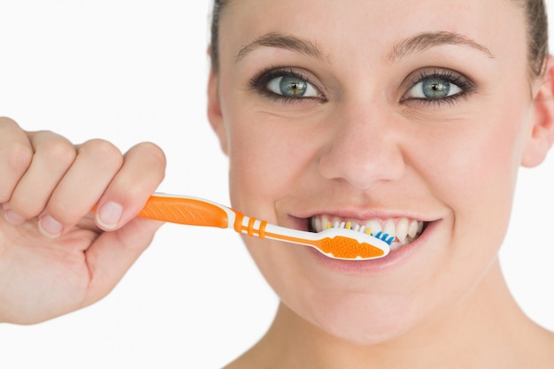 Happy woman washing her teeth