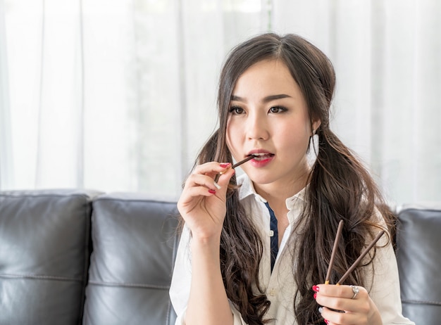 Happy woman watching TV with snack