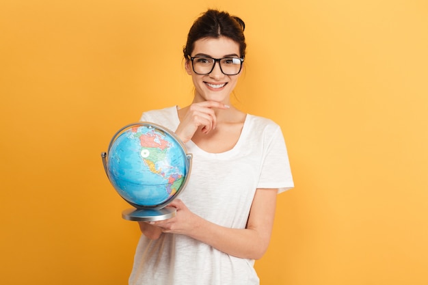 Happy woman wearing glasses holding globe.