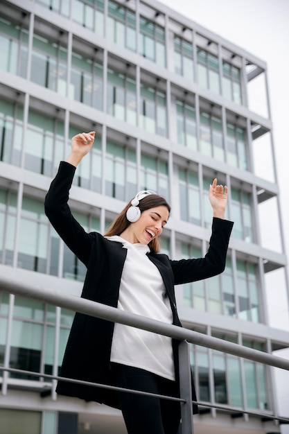 写真 ヘッドフォンミディアムショットを身に着けている幸せな女性