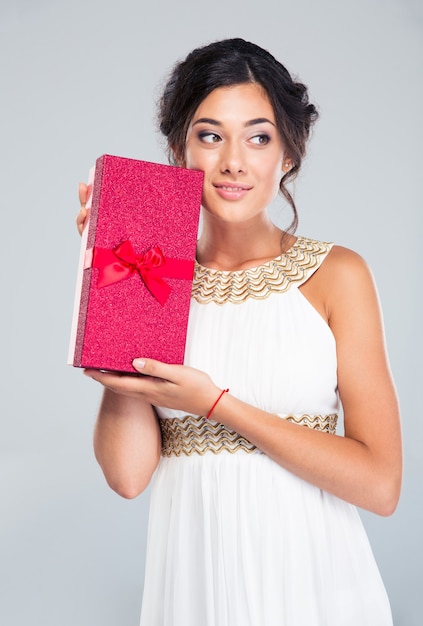 Happy woman in white dress holding gift box