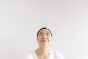 Happy woman in white t-shirt found an idea and looking at the empty background. concept of happy idea advertising.