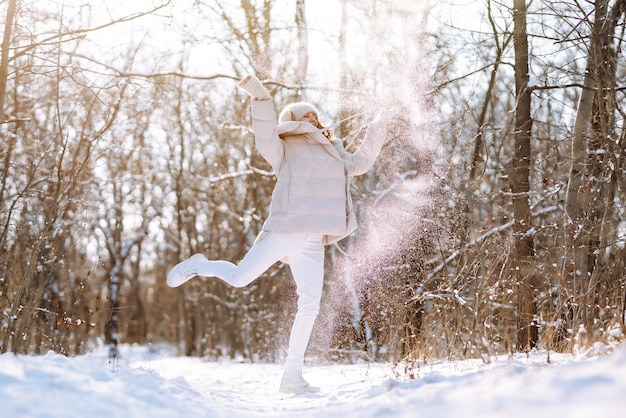 눈 덮인 공원에서 산책하는 겨울 스타일의 옷을 입은 행복한 여자 자연 휴가 여행 컨셉