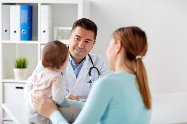 Photo happy woman with baby and doctor at clinic