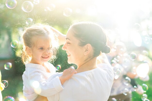 写真 泡のそばに立っている娘と幸せな女性