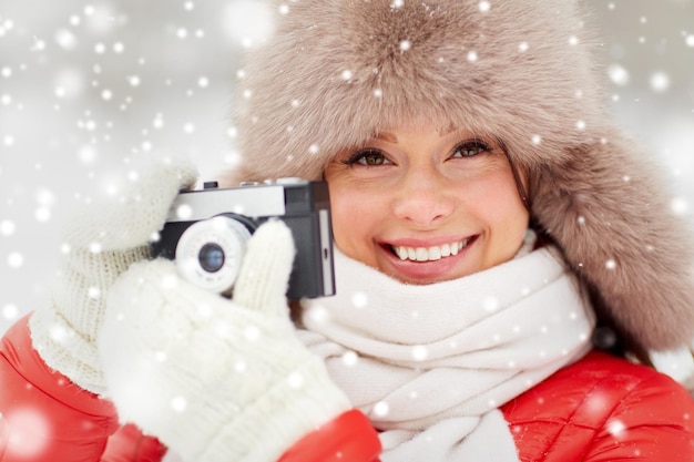Foto donna felice con la telecamera all'aperto in inverno