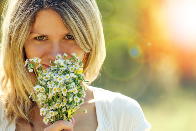 Happy woman with flowers in love playing outdoors in the park