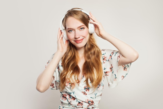 Happy woman with headphones Redhead model girl having fun on white background