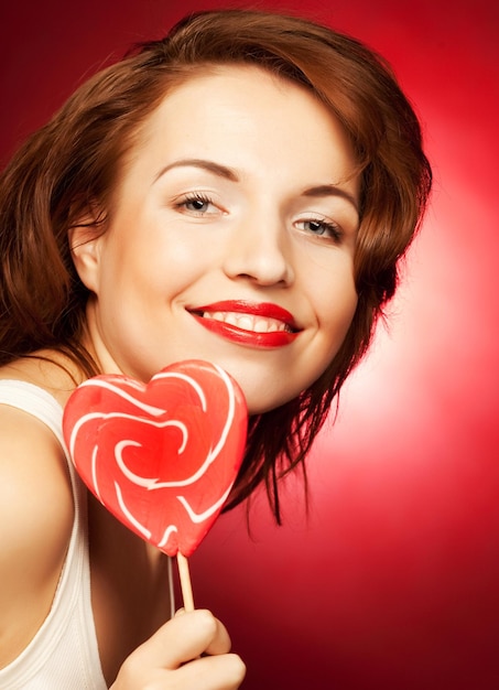 Happy woman with heart candy lolly pop