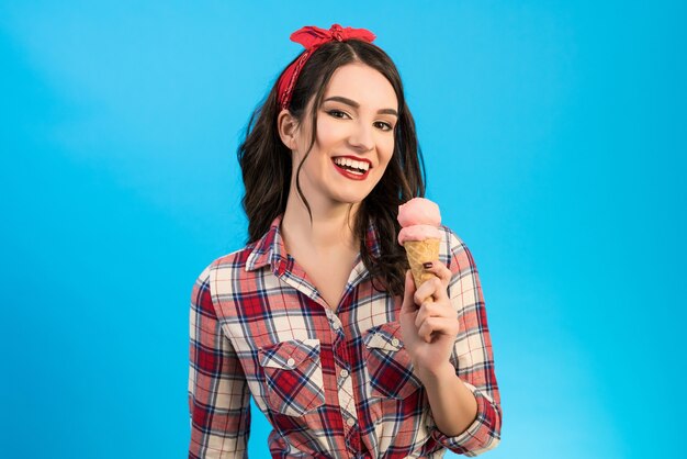 The happy woman with an ice cream on the blue background