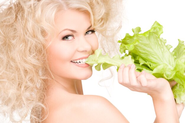 happy woman with lettuce over white wall