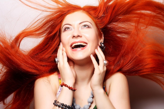 Счастливая женщина с длинными распущенными рыжими волосами