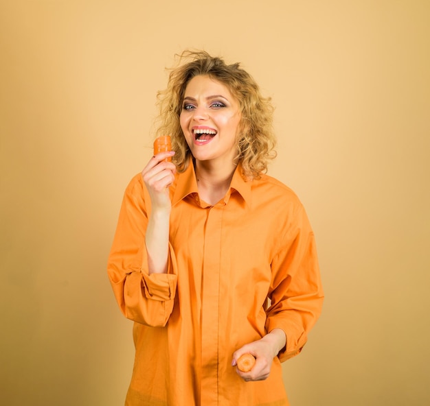 Happy woman with organic carrot enjoying healthy food vegetable having good impact on teeth smiling