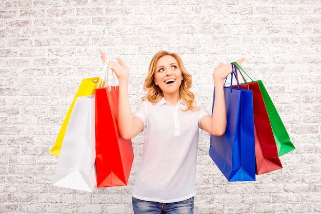 Счастливая женщина с бумажными мешками делает покупки в торговом центре