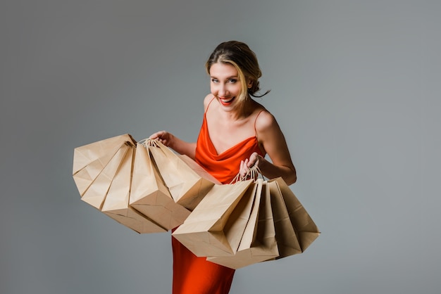 Happy woman with shopping bags against grey background Christmas or Black friday