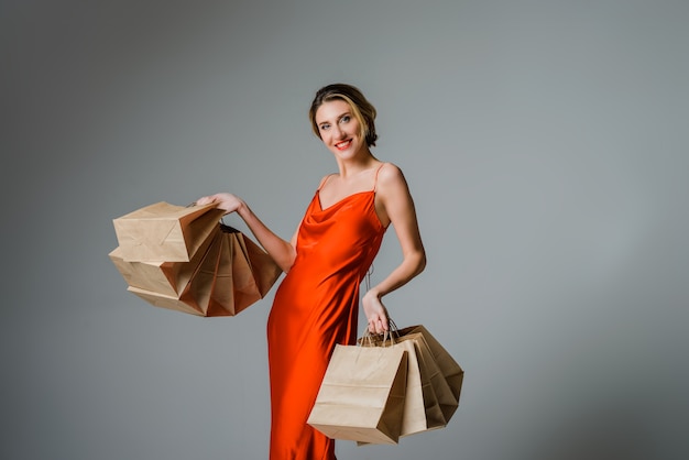 Happy woman with shopping bags against grey background Christmas or Black friday