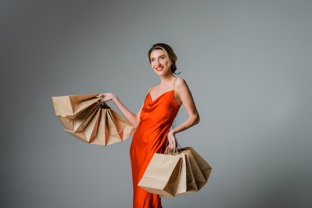 Photo happy woman with shopping bags against grey background christmas or black friday